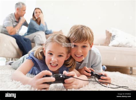 Cheerful children playing video games with their parents on the Stock ...