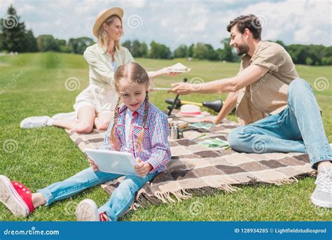 Cute Little Child Using Digital Tablet while Resting with Parents Stock ...