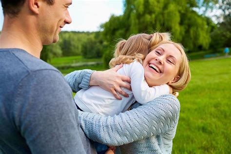 parents hugging blonde daughter - Employers For Childcare