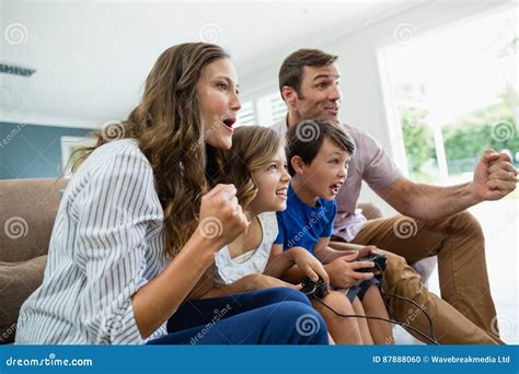 Excited Family Playing Video Games Together in Living Room Stock Photo ...