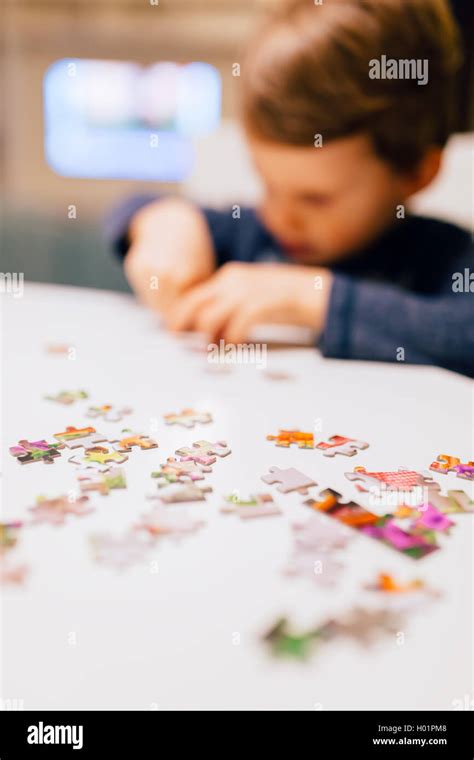 2 year old child concentrating and solving jigsaw puzzle Stock Photo ...