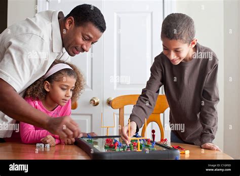 Family playing board game together Stock Photo - Alamy
