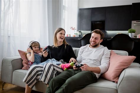Free Photo | Laughing family playing video games on sofa