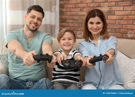 Happy Family Playing Video Games on Sofa Stock Image - Image of female ...