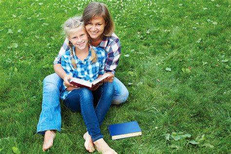 Parent and Child Reading Books Together in the Park Stock Photo - Image ...