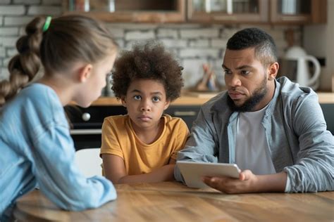 Parents discussing screen time limits with child tablet on table ...