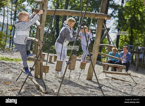 Happy kids playing in the playground under the supervision of parents ...