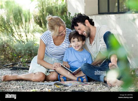Parents reading book with child Stock Photo - Alamy