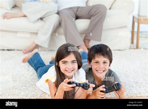 Children playing videogames while parents are talking Stock Photo - Alamy