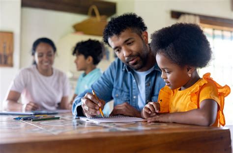 Parents Guiding Their Children While They Are Homeschooling Stock Photo ...