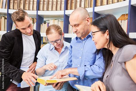 Group of people researching together in a book Stock Photo | Adobe Stock