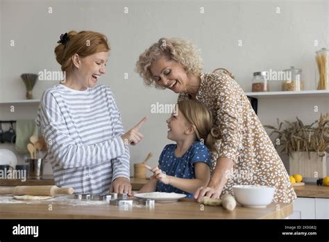 Playful multi-generational family having fun, laughing, enjoy cookery ...