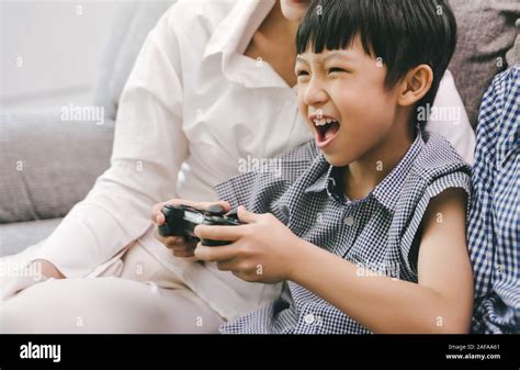 Son and parent family playing video game at home Stock Photo - Alamy