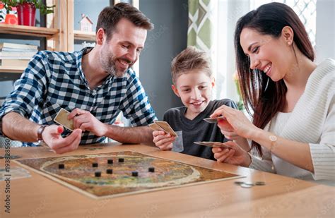 Happy family playing board game at home Stock-Foto | Adobe Stock