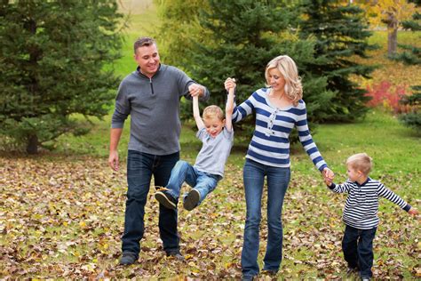 Family walking and holding hands in a park in autumn; Edmonton, Alberta ...