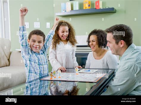 Mixed race family playing board game Stock Photo - Alamy