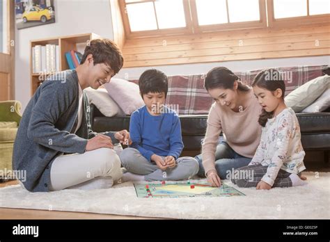 Harmonious family playing a board game together in living room Stock ...