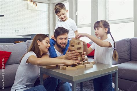 Happy family playing board games at home. Mother, father and children ...
