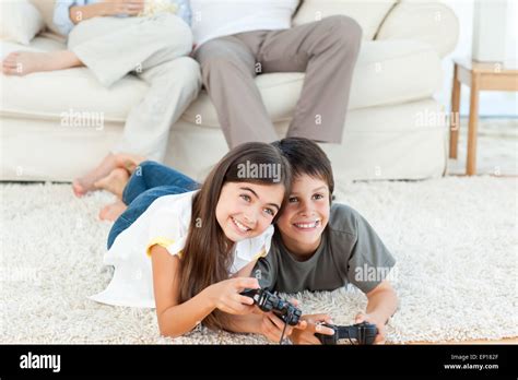Children playing videogames while parents are talking Stock Photo - Alamy