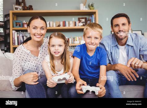 Smiling children playing video games with parents Stock Photo - Alamy