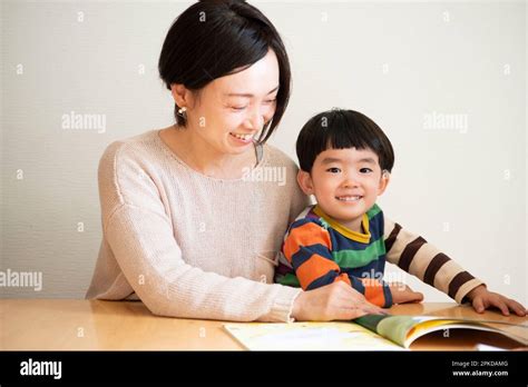 Parent and child reading a picture book Stock Photo - Alamy