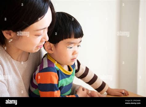 Parent and child reading a book Stock Photo - Alamy