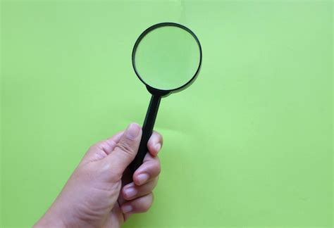 Premium Photo | Cropped image of person holding magnifying glass ...